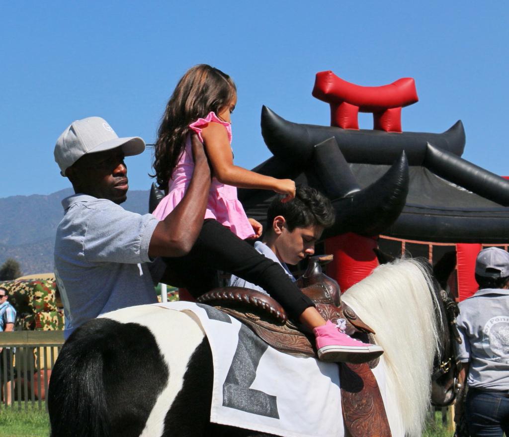 Gladney helping a child aboard one of his ponies. (Julie June Stewart photo)